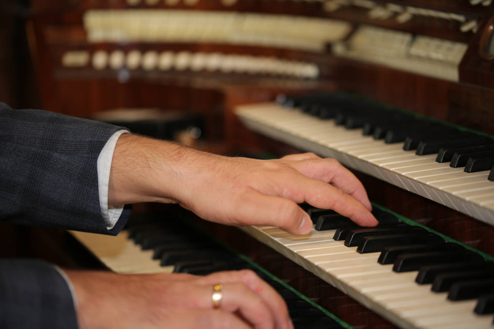 Foto von den Händen eines Organisten, der gerade orgel spielt.